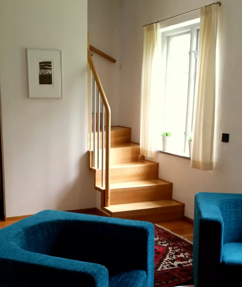 An overview in apartment 2 at the housing area Biskopshusets annex showing two armchairs and the stairs to the second floor (picture)