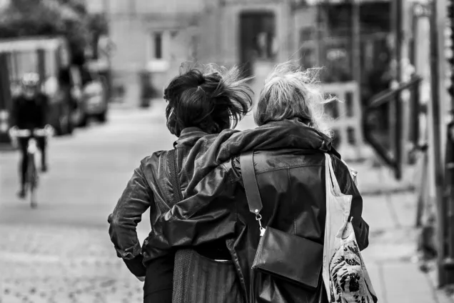 Two students walking away on a cobble-stoned street. Black-and-white photo by Kennet Ruona.