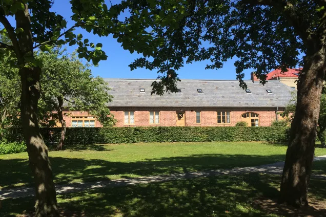 View of a terraced building (Annexet) with a hedge, lawn and trees in the foreground. Photo by LU Accommodation.