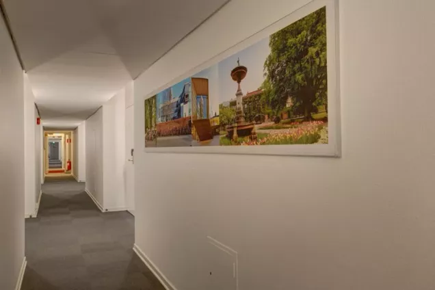 Carpeted hallway with photos of Lund on white walls. Photo by LU Accommodation.