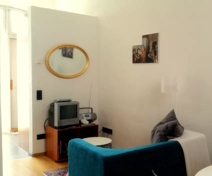 An overview of the living room in apartment 4 at the housing area Biskopshusets annex showing a sofa and mirror (picture)