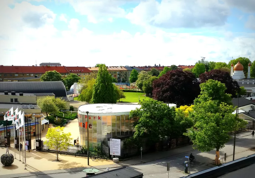 Bird's eye view of Folkets Park from across the street, with entrance and cafe to the left, and trees and stretching forwards. Photo by LU Accommodation.