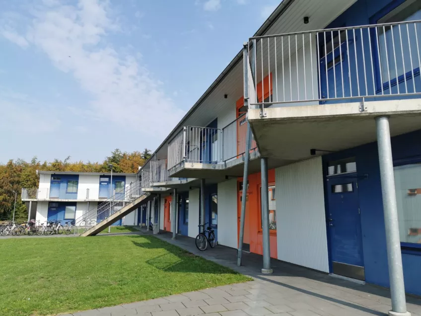 View of two two-storey terraced houses with blue and orange doors. Photo by Ellen Jokela Måsbäck.
