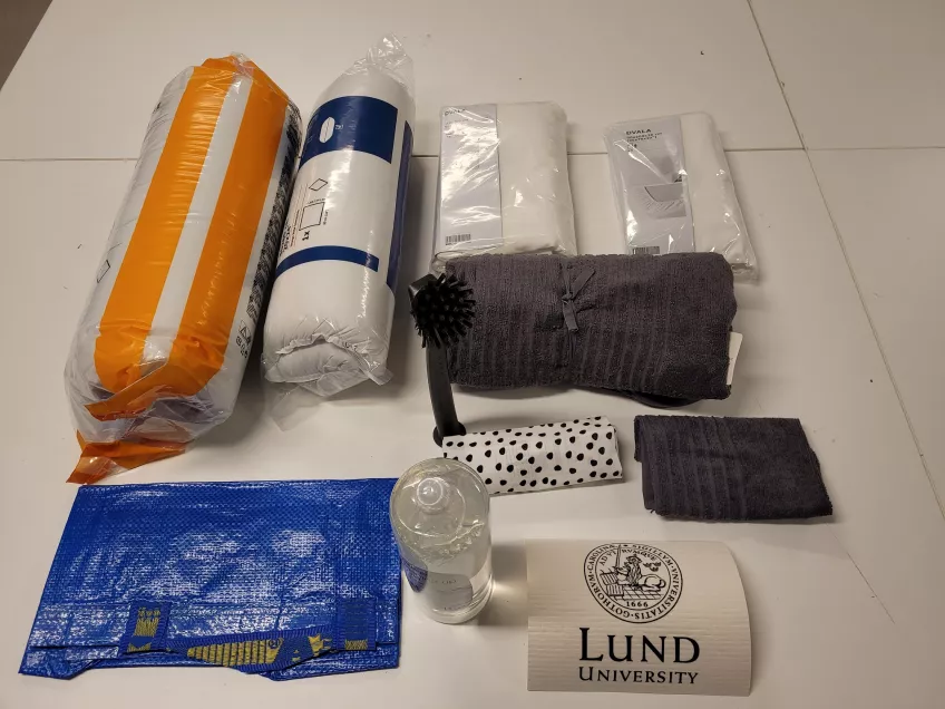 A picture of all items that are included in the bed package during 2022, showing from the top left duvet, pillow, bedlinen, bedsheet, towel, dish brush, dish towel, small towel, bag, washing up liquid, dishcloth (picture)
