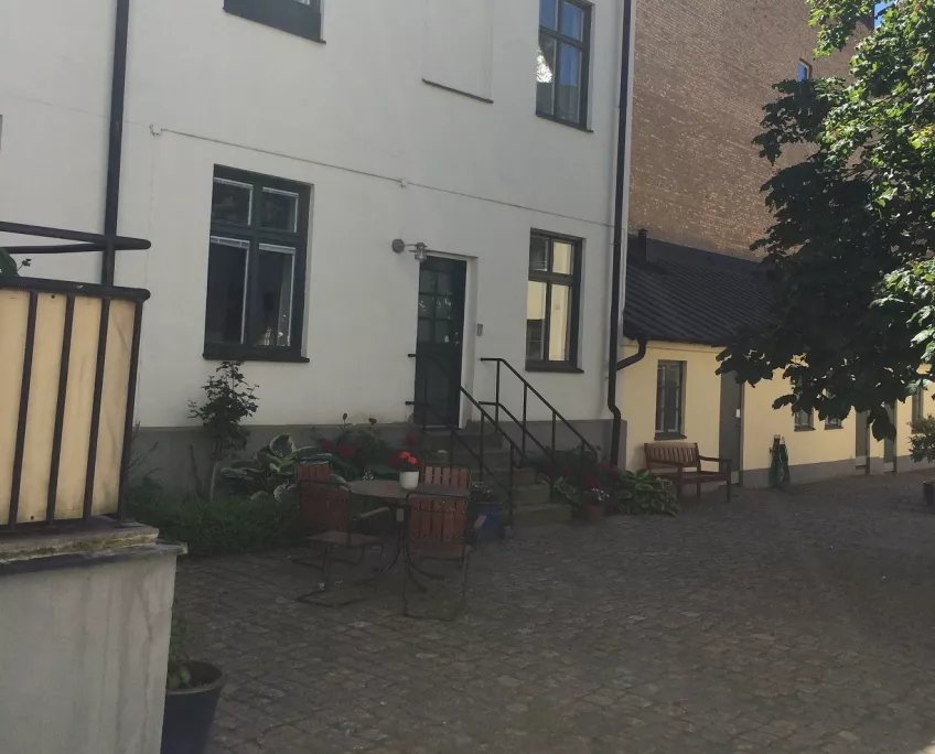 An overview of the building where the apartment at the housing area Kyrkogatan is located. The picture shows a white building in the courtyard (picture)