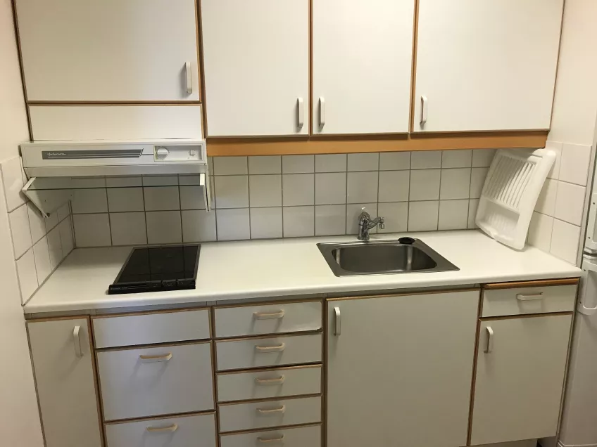 An overview of the kitchen at the housing area Kyrkogatan showing the kitchen area with sink, cooker and cupboards (picture)