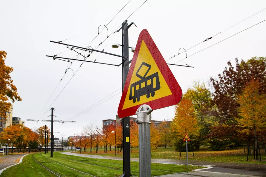 In the middle a triangular road sign with a tramcar. Behind it the tram cables and road (picture by Charlotte Carlberg Bärg)
