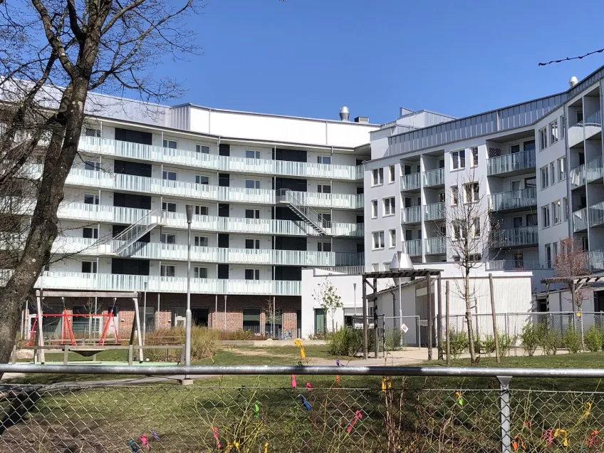 The housing area Sofieberg viewed from the south of the building showing the white builing and the playground at the daycare in front of it (Picture)