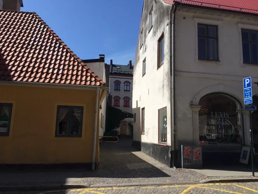 A view of the entrance to the courtyard where the housing area Stora Gråbrödersgatan is located. The entrance is between two buildings (picture).